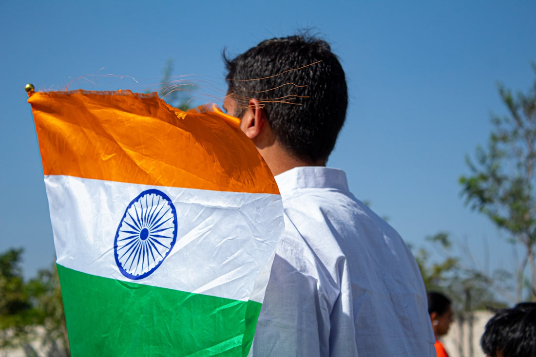a man holding an indian flag in his hands